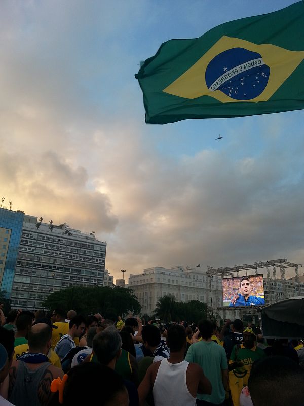 Los brasileños siguen el himno de su país antes del comienzo del partido.