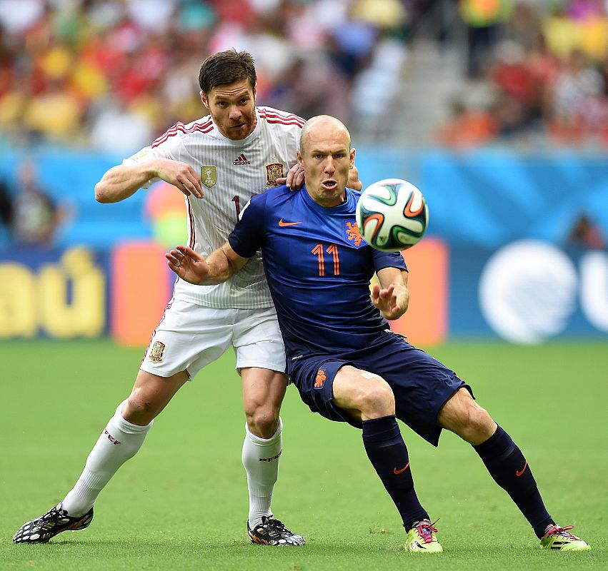 Xabi Alonso intenta que Arjen Robben no pueda controlar el balón.