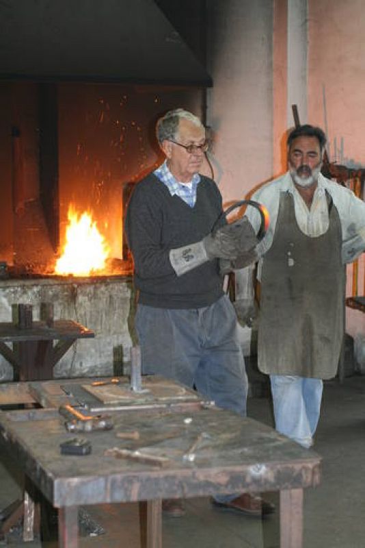   Martín Chirino, en la forja del taller, junto a Rafael Monagas