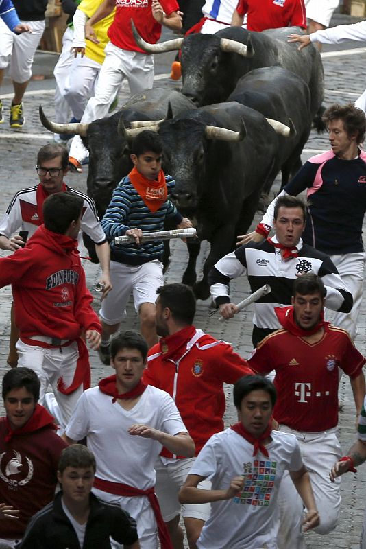 Un grupo de mozos corre delante de cuatro de los toros de Miura en el más peligroso de los encierros de los sanfermines 2014