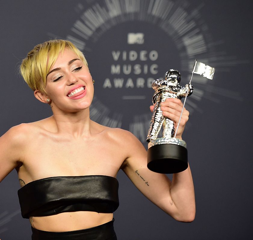 Miley Cyrus posa con su premio al "Mejor Vídeo Musical" del año por "Wrecking Ball"