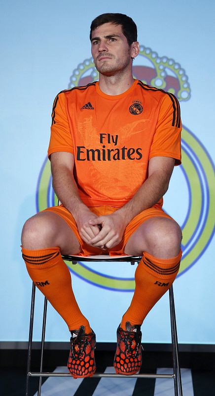 El capitán y portero del Real Madrid, Iker Casillas, posa con una camiseta naranja que en el pecho tiene como novedad el diseño de dos dragones entrelazados.