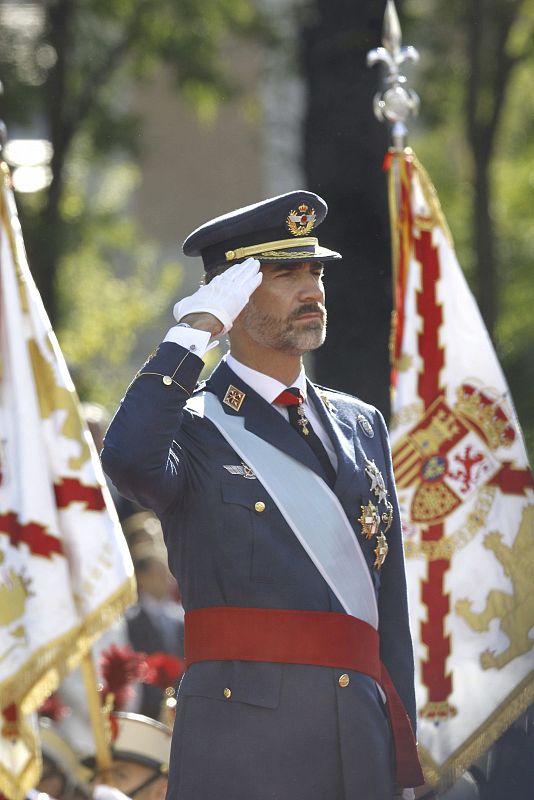 El rey Don Felipe, saluda mientras suena el himno nacional dentro de los actos de celebración del Día de la Fiesta Nacional.