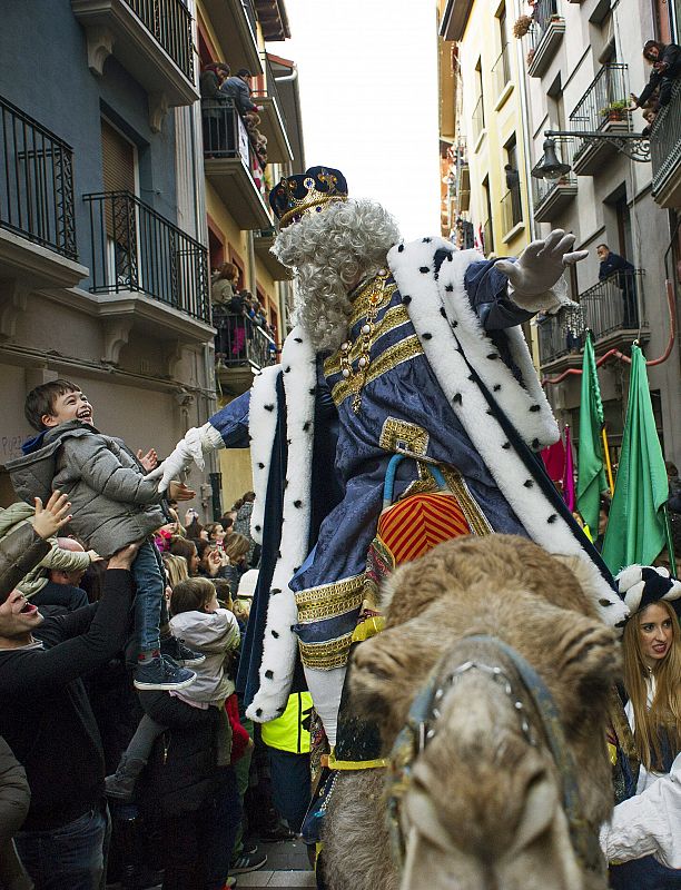 El rey Melchor saluda a un niño a su llegada a Pamplona