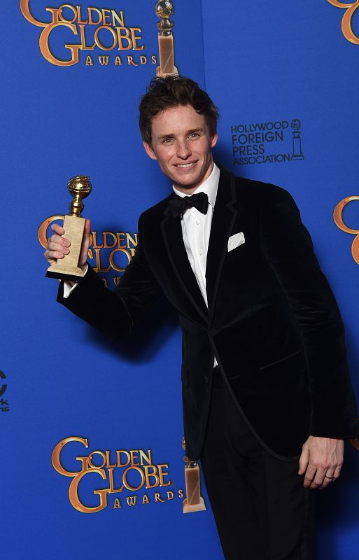 El joven actor Eddie Redmayne sujeta ante la prensa su premio a mejor actor de drama por su papel en 'La Teoría del Todo'.