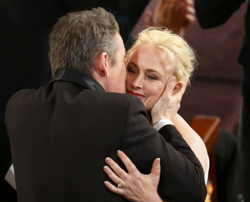 El actor Ethan Hawke felicita a Patricia Arquette, mejor actriz secundaria.