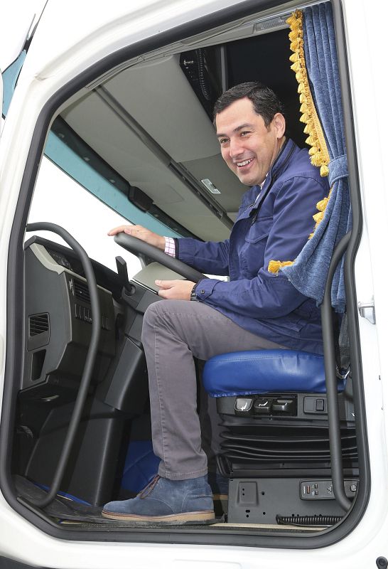 El candidato del PP, Juanma Moreno, subido a un vehículo durante la visita a la empresa Transportes Zaragoza en El Ejido (Almería), donde ha hecho promesas electorales a los transportistas.