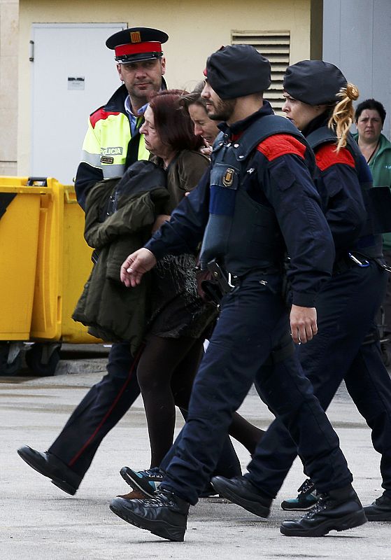 Agentes de los Mossos acompañan a varios familiares de pasajeros del avión de Germanwings en el aeropuerto de El Prat, en Barcelona.