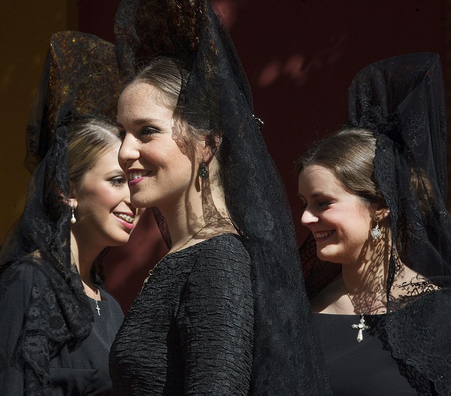 Varias jóvenes vestidas de mantilla esperan para visitar al Cristo del Gran Poder este jueves en Sevilla