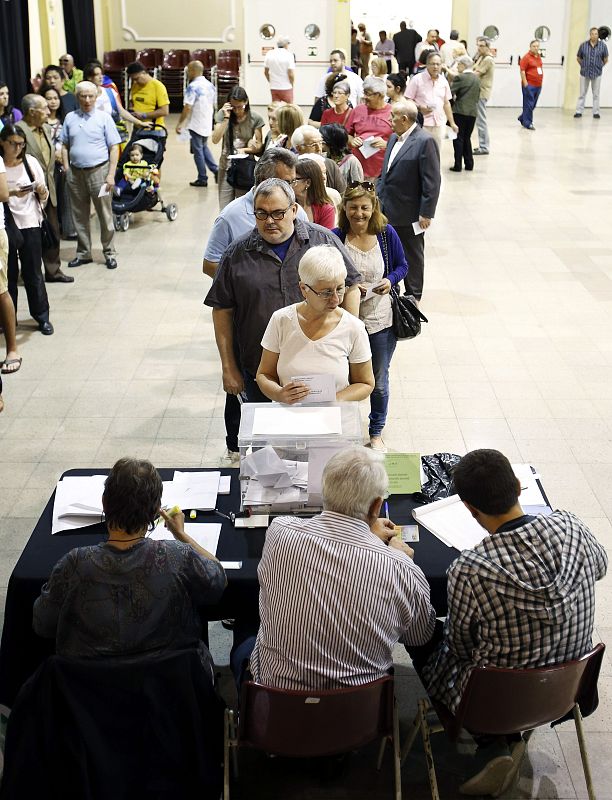 Decenas de ciudadanos hacen cola en el Casinet de Hostafrancs de Barcelona, en el barrio de Hostafrancs.