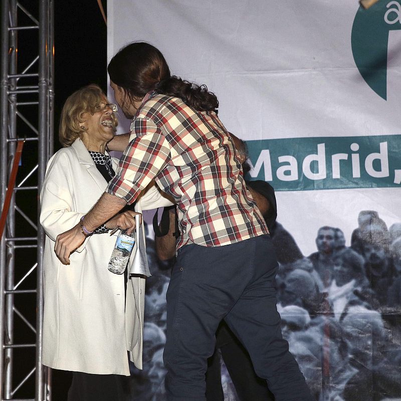 Manuel Carmena, candidata a la alcaldía por Ahora Madrid, es abrazada por Pablo Iglesias, líder de Podemos, tras conocer los resultados electorales.