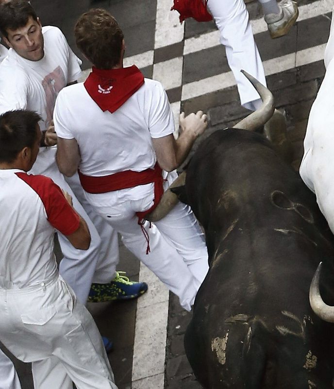 Un toro de Jandilla alcanza a uno de los corredores en la calle Estafeta