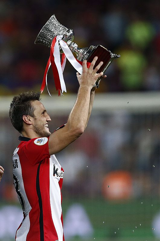 El capitán del Athletic Club, Carlos Gurpegi,  ofrece a la afición que ha viajado hasta Barcelona el trofeo de la Supercopa de España tras el partido de vuelta de la final jugada con el FC Barcelona en el Camp Nou.