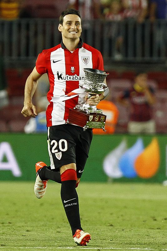 Aritz Aduriz, goleador  de la eliminatoria, corre con la Supercopa de España.