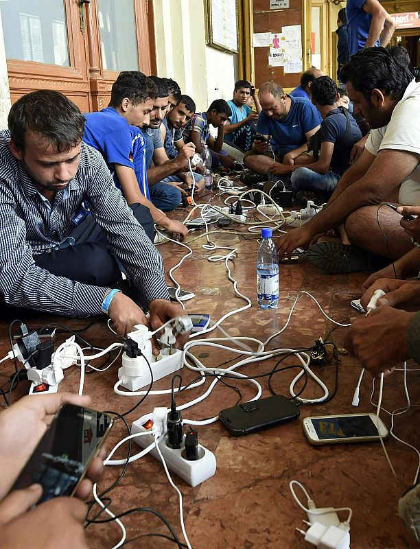 Inmigrantes cargan sus teléfonos móviles en la estación Keleti de Budapest, Hungría, desde donde intentan llegar en tren a Austria