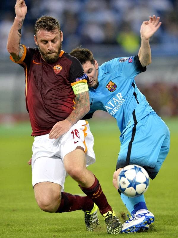 El italiano De Rossi y el argentino Messi pugnan por un balón