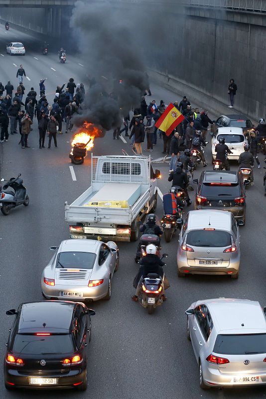 Un grupo de taxistas, que incluye a varios españoles, tratan de impedir el tráfico en la circunvalación parisina