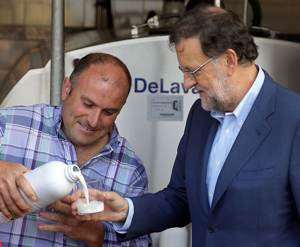 El presidente del Gobierno en funciones, Mariano Rajoy, junto al ganadero José Luis Fernández, en la localidad asturiana de San Martín de Podes, en el municipio de Gozón.