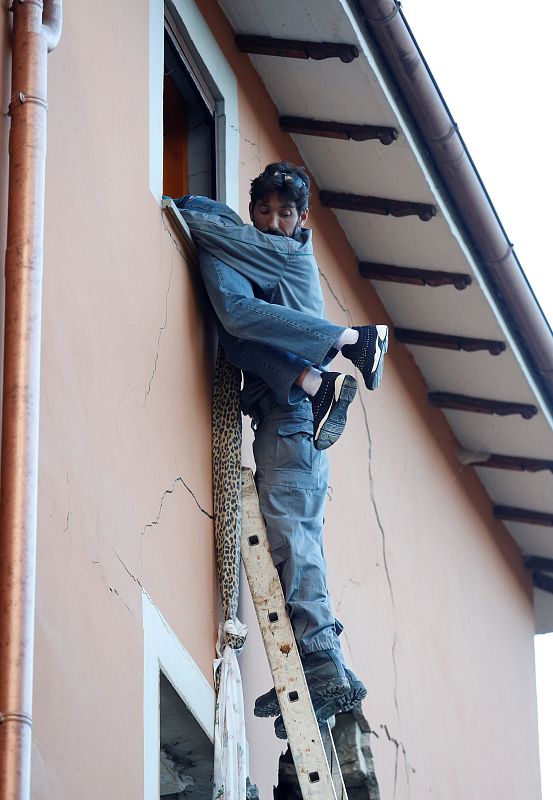 Un agente rescata a una persona de una vivienda de Amatrice.