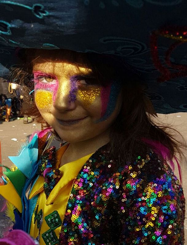 Una niña sonríe a la cámara tras participar en el desfile de comparsas del carnaval de Badajoz