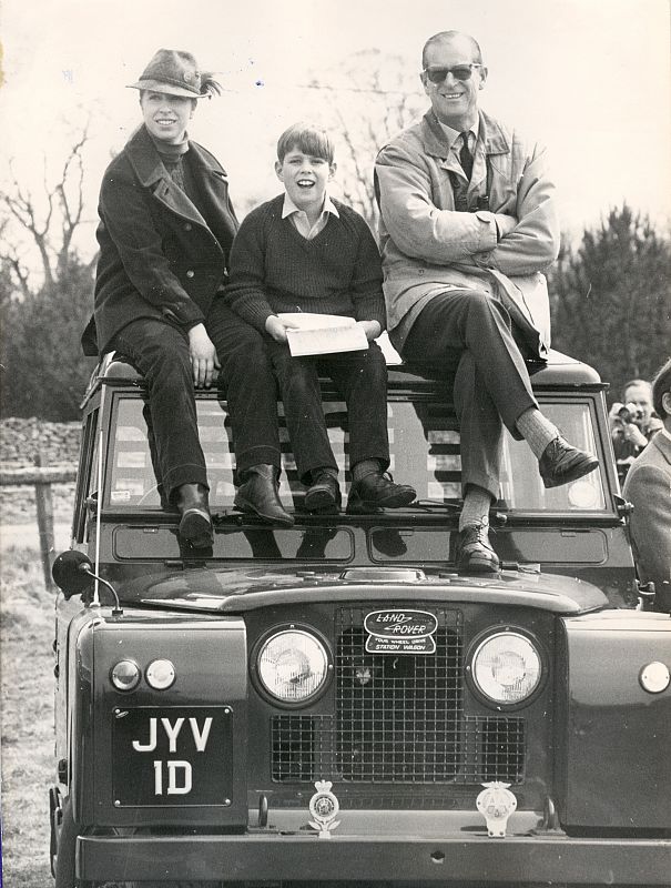 El duque de Edimburgo, Felipe Mountbatten, subido en el capó de un Land Rover con la reina Isabel y su hijo, el príncipe Carlos.