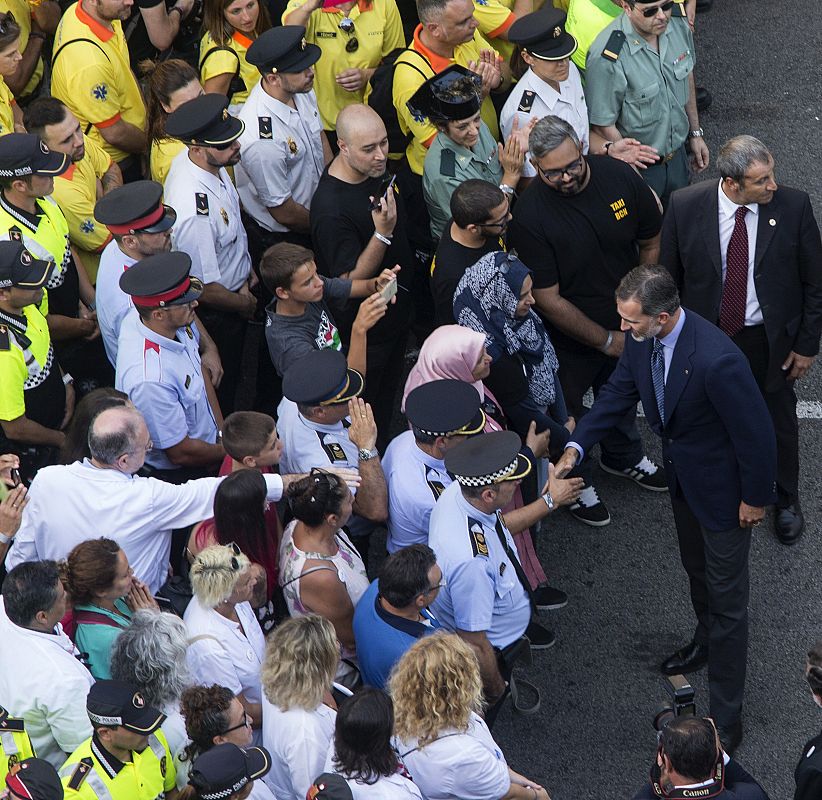 El rey Felipe saluda a los 75 representantes de todos los cuerpos de seguridad (Mossos, Policía Nacional, Guardia Civil y policías locales) y de emergencias así como a ciudadanos mulsumanes en la cabecera de la manifestación.