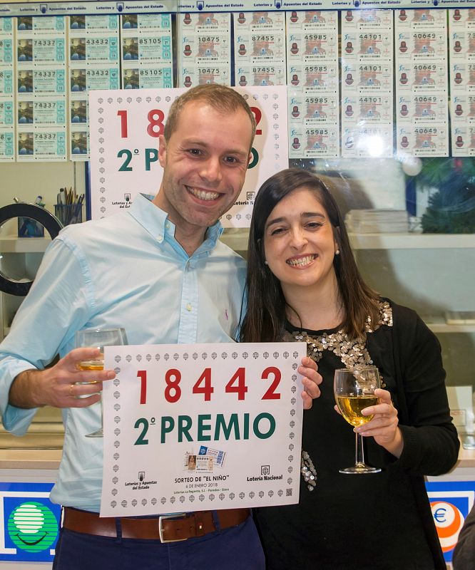 En Paredes, Asturias, el responsable de la administración, Sergio Díez, acompañado de su esposa, celebran la suerte de repartir el segundo premio