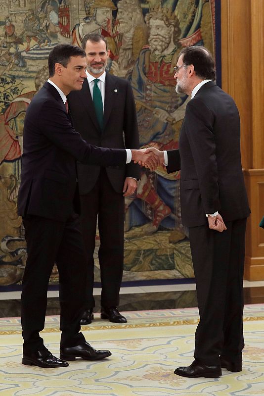 El líder del PSOE, Pedro Sánchez, saluda al jefe del Ejecutivo saliente, Mariano Rajoy, en presencia del rey