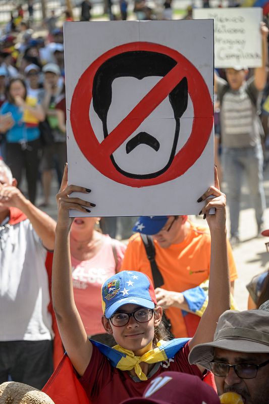 Un opositor al régimen de Maduro participa en una marcha en Santiago