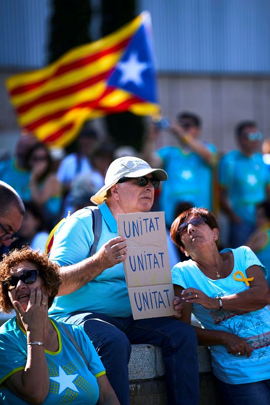 Uno de los participantes en la manifestación muestra una pancarta con el mensaje "Unidad, unidad, unidad" ('unitat, unitat, unitat' en catalán).