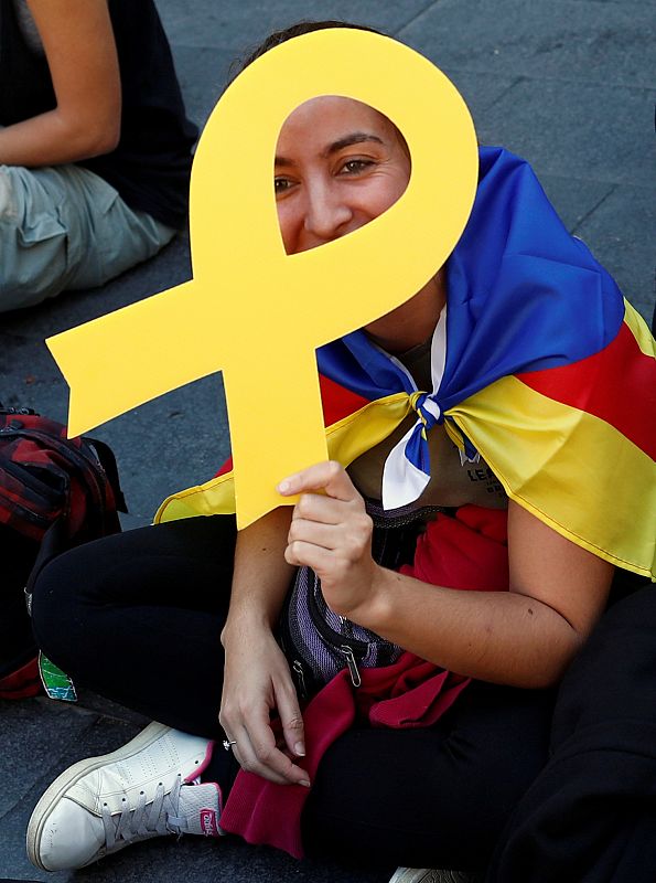 Una estudiante, que porta una estelada, muestra un lazo amarillo en apoyo de los líderes independentistas presos.