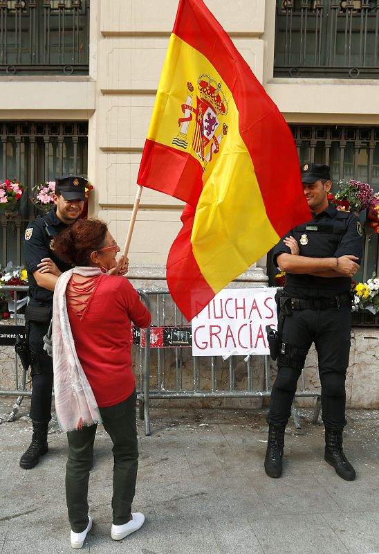 Una mujer habla con los agentes que custodian la Jefatura de Policía en Barcelona.