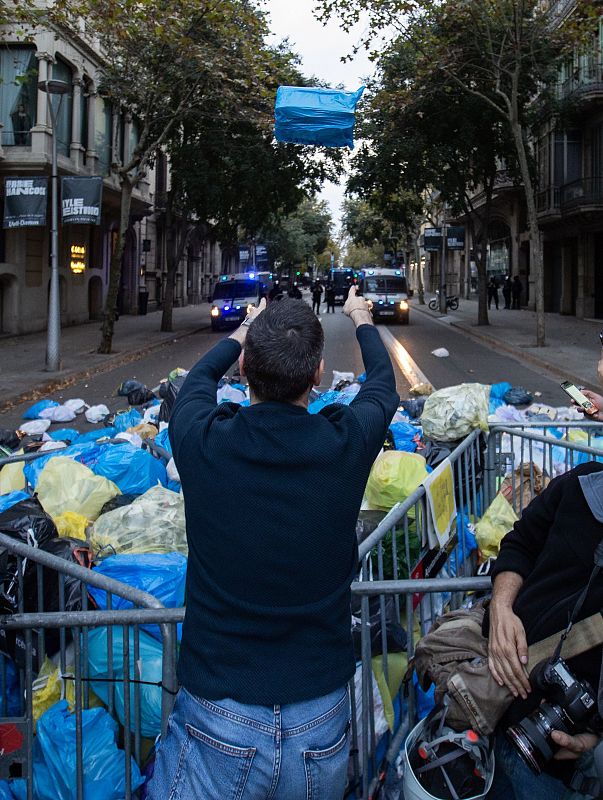 Un dels manifestants llança la bossa d'escombraries com a símbol de protesta