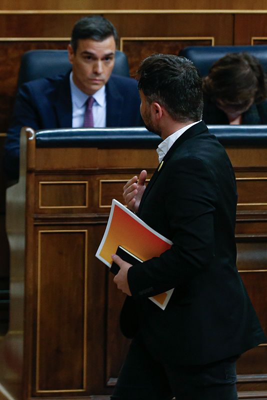 El portavoz de ERC, Gabriel Rufián, pasa por delante del candidato a la Presidencia del Gobierno, Pedro Sánchez, en el Congreso de los Diputados en la primera jornada de la sesión de investidura de Pedro Sánchez como presidente del Gobierno.