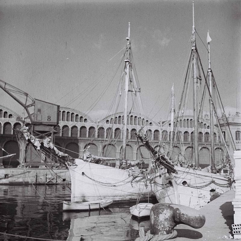 Dos barcos de vela permanecen amarrados en el puerto de Barcelona.