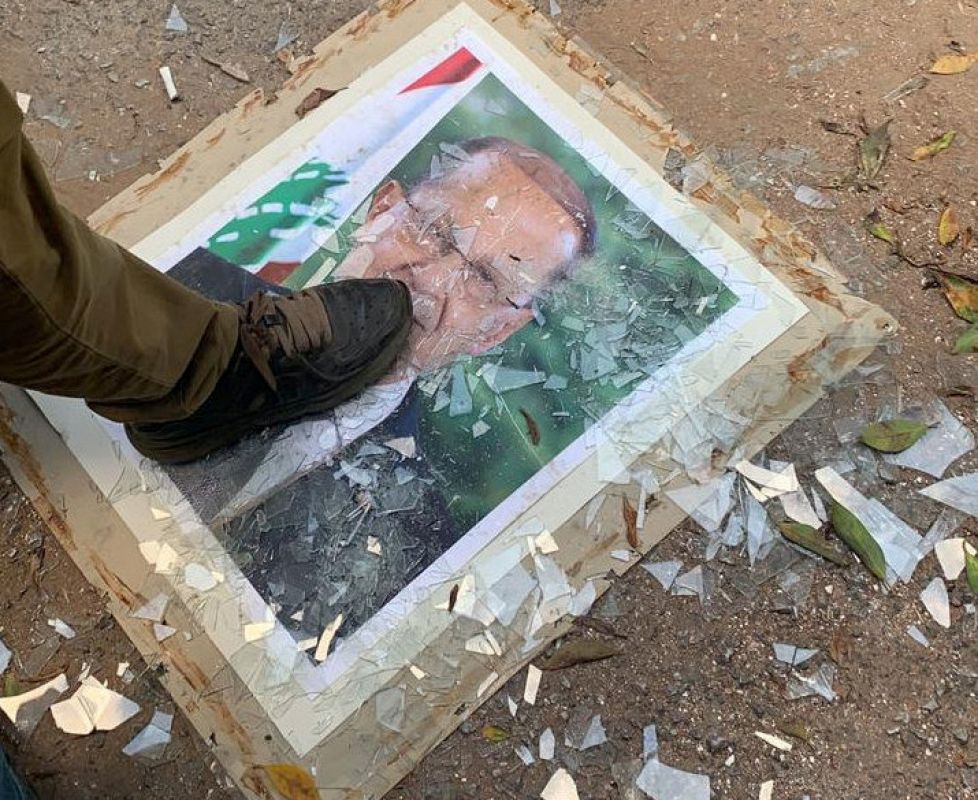 Un manifestante pisotea el retrato del presidente del país, Michel Aoun