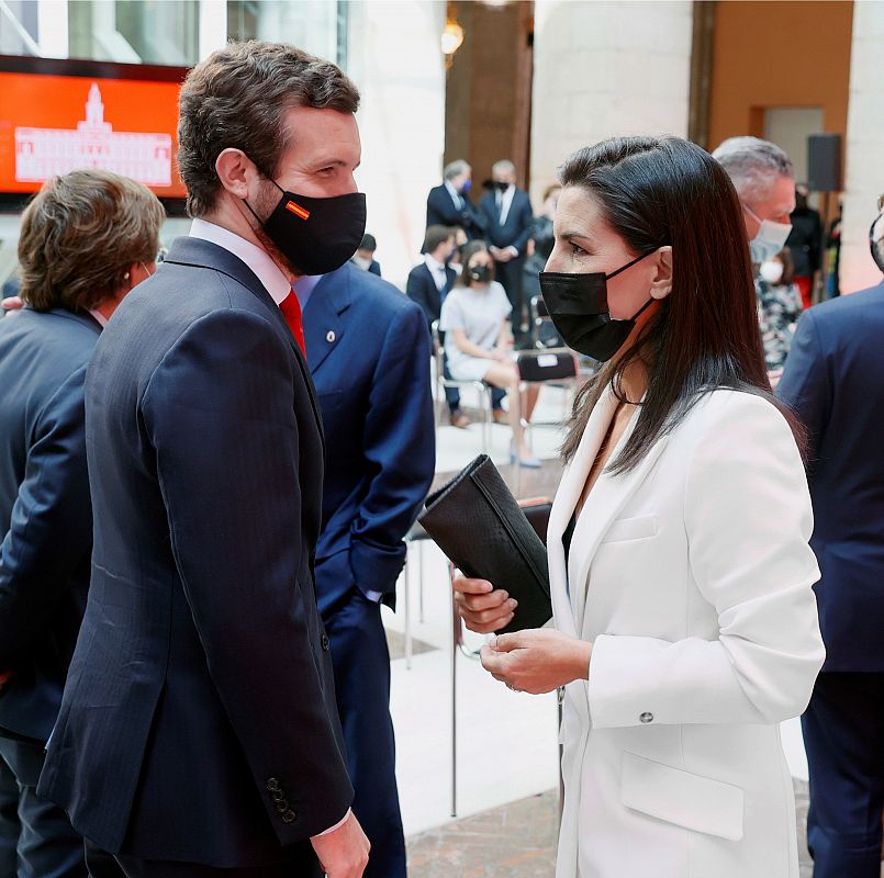 El líder del PP, Pablo Casado, conversa con la candidata de Vox a la Comunidad de Madrid, Rocío Monasterio, durante los actos con motivo de la celebración del Dos de Mayo en la Real Casa de Correos de la Puerta del Sol.