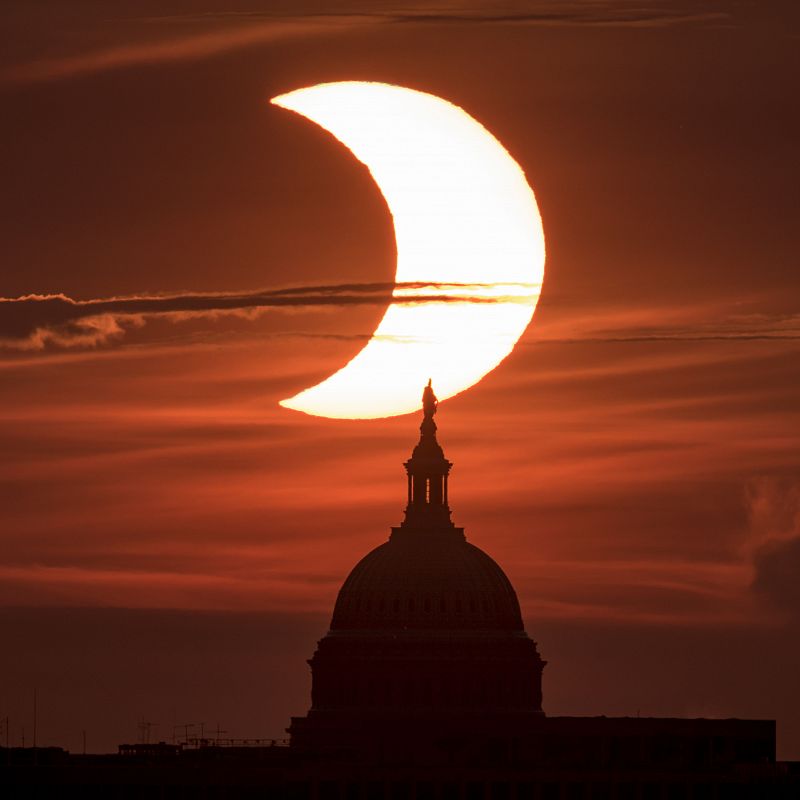 Vista del fenómeno astronómico desde Arlington, Virginia, en Estados Unidos, con el Sol saliendo detrás del edificio United States Capitol.