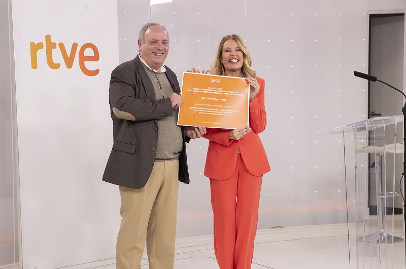 Entrega de diplomas de Impulsa Visión en RTVE, donde un hombre entrega el diploma a una mujer vestida de naranja.
