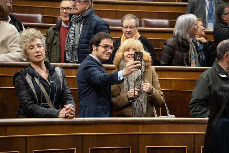 El diputado de VOX José María Figaredo se hace un selfie con una señora en el hemiciclo