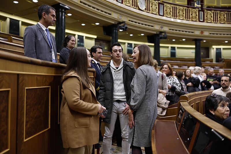 La presidenta del Congreso, Francina Armengol, conversa con dos personas en el hemiciclo