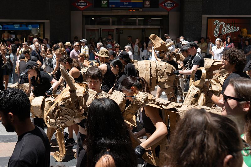 Representación callejera de una estampida con figuras de cartón entre peatones en Madrid.  Imagen de Antxón López Landajuela.