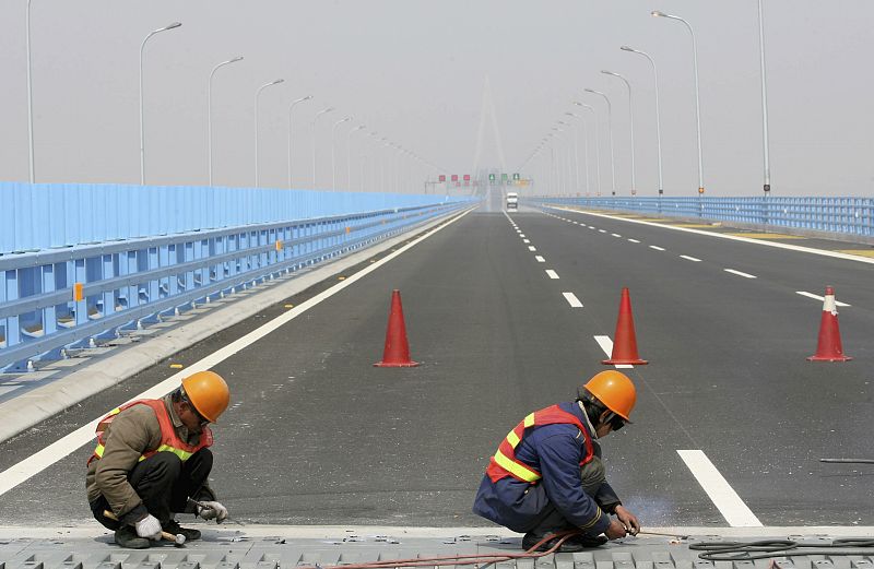 Labourers work on the construction site of Hangzhou Bay Bridge in Ningbo,