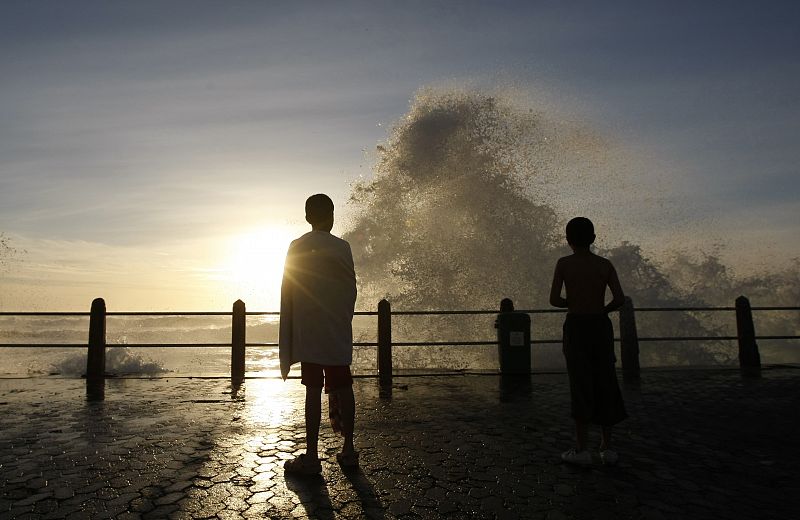 Unos niños juegan en un mirador de una playa de Ciudad del Cabo, ajenos a las olas de más de seis metros que el temporal ha llevado a la capital legislativa de Sudáfrica.