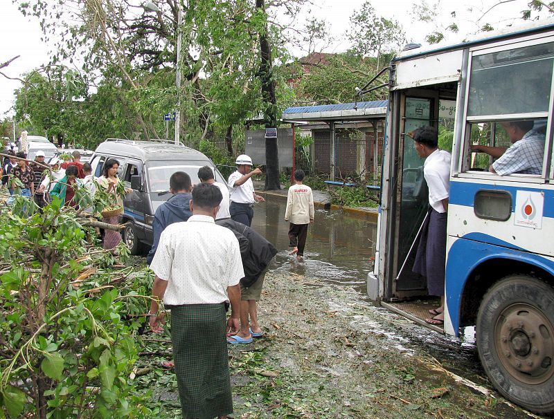 VARIOS RESIDENTES DE YANGON Y ALGUNOS AGENTES DE POLICÍA EN UNA CALLE BIRMANA TRAS EL PASO DEL CICLÓN NARGIS