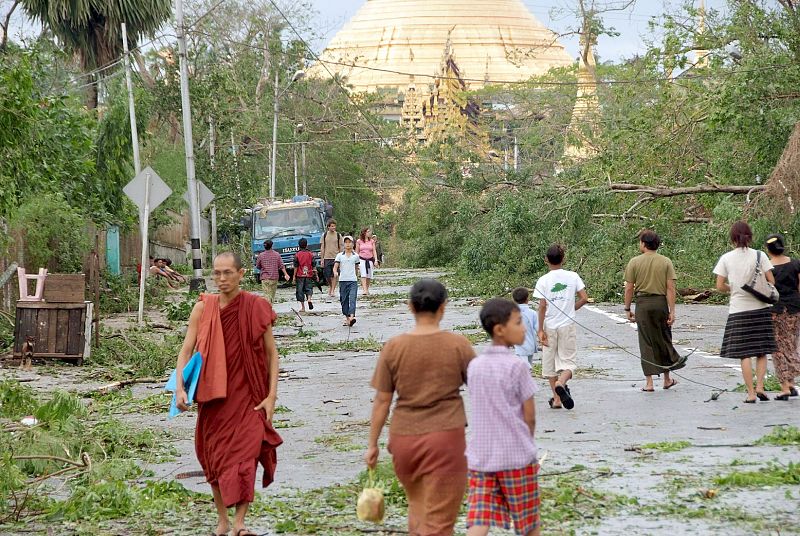 UN GRUPO DE PERSONAS SE ABRE PASO ENTRE VARIOS ÁRBOLES EN EL SUELO EN YANGON, BIRMANIA