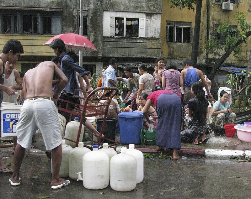 Los damnificados por el ciclón 'Nargis' recogen agua en una calle de Yangon