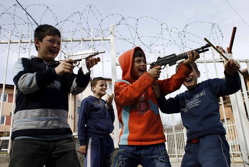 Serbian boys play with plastic toy guns in front of United Nations court building in the ethnically divided Kosovo town of Mitrovica