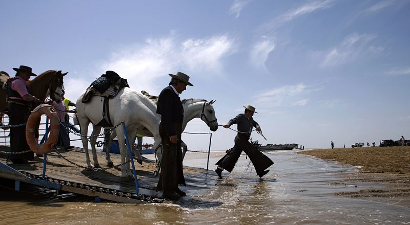 Pilgrims pull their horses off a river-crossing ferry while en route to the shrine of El Rocio in Sanlucar de Barrameda
