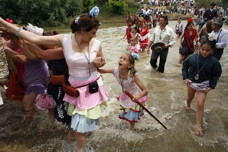 Pilgrims walk across the Quema River during a pilgrimage to the shrine of El Rocio in the province of Seville